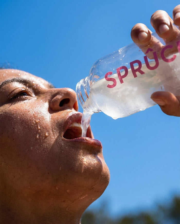Drinking from a Spruce bottle against a blue sky