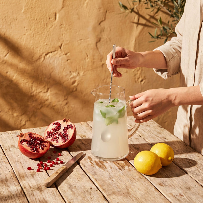 A jug and glasses of Spruce Lemon & Pomegranate daily electrolytes